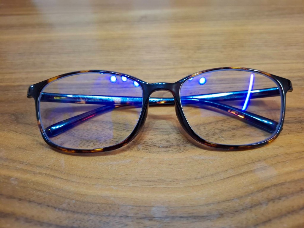 上から見た鼈甲柄のメガネ。レンズに照明の青みが反射し、ブルーライトカット用コーティングが視認できる